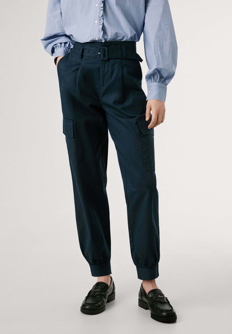 Marinblå cargobyxor med bälte vid hög midja, som har sidofickor, avsmalnande anklar och ett mjukt, lätt tyg. I kombination med svarta loafers.