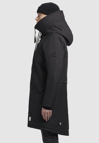 Czarny, ocieplany parka z wysokim kołnierzem, regulowanym kapturem, bocznymi kieszeniami i naszywką z logo. Gładki materiał i prosty krój.