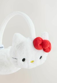 White plush handbag shaped like a cat's head, featuring a red bow, embroidered eyes, and a soft handle. Smooth texture throughout.