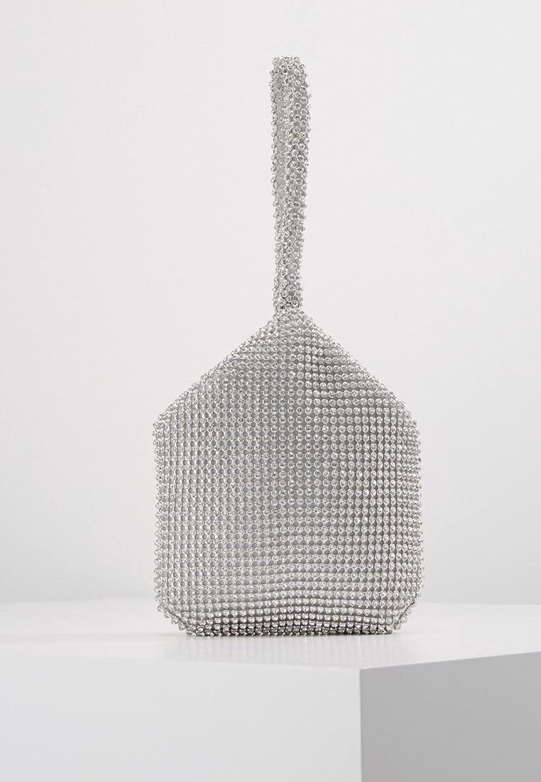 Petit sac de soirée argenté recouvert de strass étincelants avec une petite anse, présenté sur un socle blanc sur un fond uni.