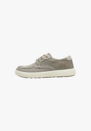 Zapatilla deportiva casual de color gris claro con cordones, parte superior de tela y suela de goma blanca, mostrada de perfil sobre fondo blanco.