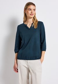 Türkisfarbener Pullover mit V-Ausschnitt, Dreiviertelärmel und elastischen Bündchen. Glatte Textur, lässige Passform und gerafftes Saumdetail.