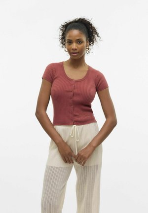 Haut court côtelé bordeaux à encolure ronde et devant à boutons, associé à un pantalon texturé beige clair avec cordon de serrage.