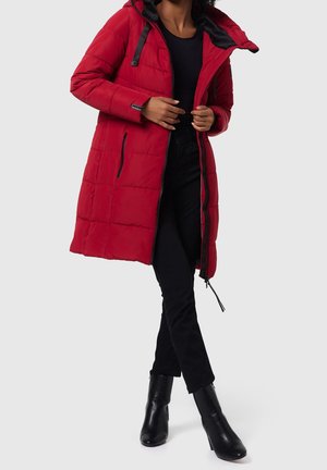 Red padded coat with a hood, featuring zippered pockets and black accents, displayed over a black top and black pants, paired with black boots.