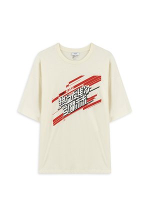 T-shirt crème à manches courtes en coton doux, avec un design graphique en texte noir et rouge audacieux sur le devant. Coupe décontractée et col rond.