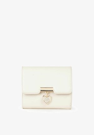 Monedero de imitación de cuero blanco con un cierre dorado y un brillante charm en forma de corazón. Presenta una forma estructurada y una textura suave.