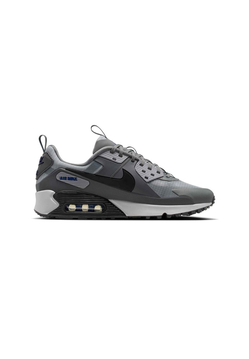 Baskets Nike Air Max grises et noires avec coussin d'air visible dans la semelle, fermeture à lacets à l'avant, et languettes de tirage sur la languette et le talon.