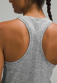 Gray athletic tank top with a racerback design, featuring a textured fabric pattern and a smooth finish. Logo detail at the upper back.