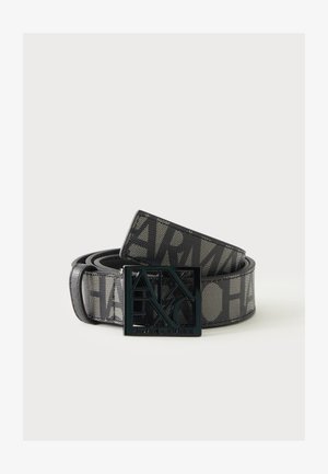 Ceinture noire Armani Exchange avec grande sangle logo à texture maille et boucle en métal découpée assortie sur fond uni.