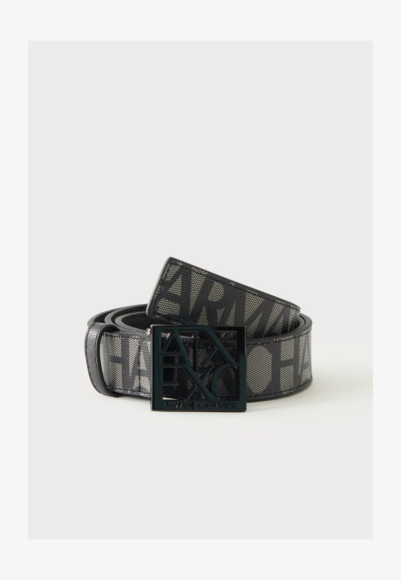 Ceinture noire Armani Exchange avec grande sangle logo à texture maille et boucle en métal découpée assortie sur fond uni.