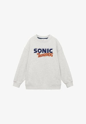 Tricou de culoare gri deschis cu inscripția "SONIC THE HEDGEHOG" în text albastru și portocaliu. Gât rotund, mâneci lungi și buzunare laterale. Material din amestec de bumbac.