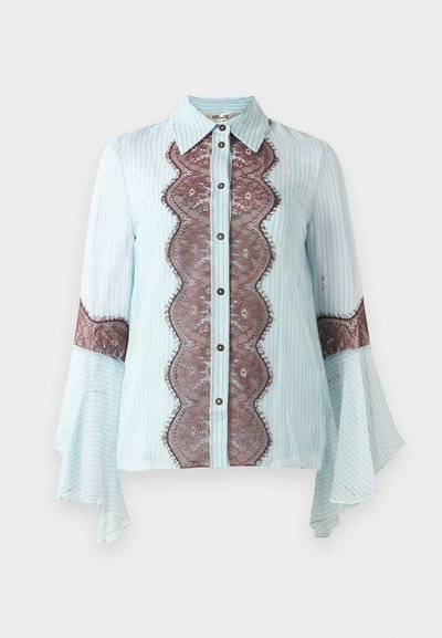 Jasnoniebieska bluzka z brązowym koronkowym akcentem i paskowanym wzorem. Ma spiczasty kołnierz, zapięcie na guziki oraz rozkloszowane rękawy.