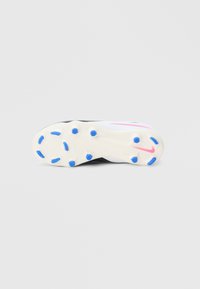 Μαύρο και άσπρο πέλμα ποδοσφαιρικού παπουτσιού με μπλε πέλματα. Διαθέτει ροζ λεπτομέρεια και υφασμένο λάστιχο για πρόσφυση. Καθαρός, λιτός σχεδιασμός.