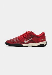 Sapatilhas baixas vermelhas com sola preta, swoosh branco da Nike, atacadores vermelhos e texto "total 90 III" no calcanhar, com padrão de pele de cobra.