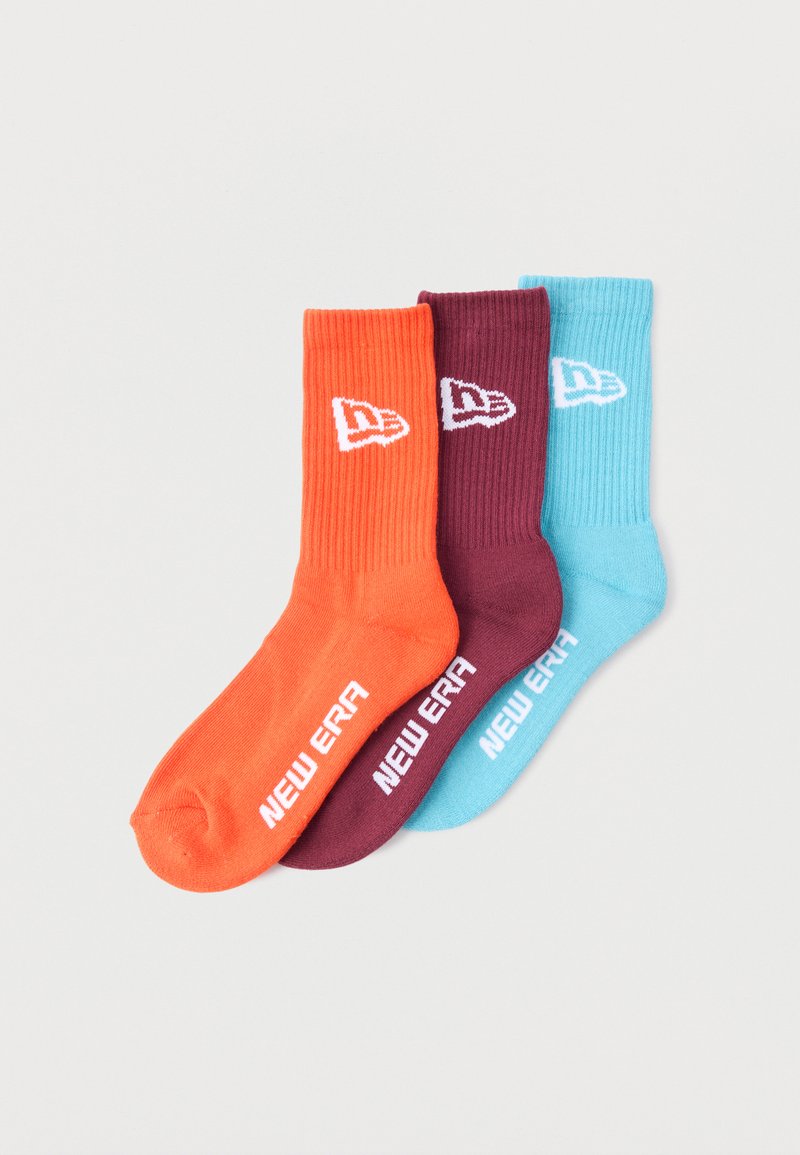 Trzy pary skarpetek: pomarańczowe, bordowe i jasnoniebieskie. Każda ma prążkowaną fakturę i biały logo "New Era".