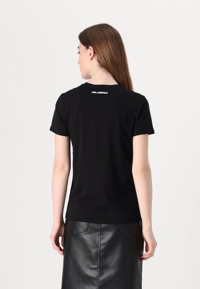 T-shirt en coton noir à manches courtes, col rond, avec un petit logo blanc "KARL LAGERFELD" à l'arrière. Texture lisse.