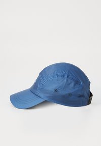 Blue cap made of lightweight, textured fabric. Features a curved brim, adjustable strap, and embroidered logo on the side.