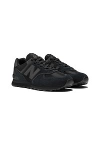 Black athletic shoes with suede and mesh materials, featuring a rounded toe, black laces, a prominent ‘N’ logo, and textured rubber soles.