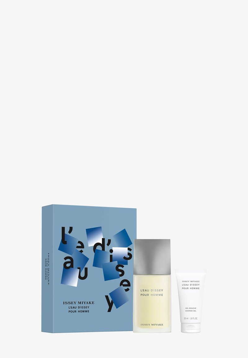 Le coffret cadeau parfum comprend un flacon en verre transparent avec un bouchon argenté et un tube blanc de gel douche, emballés dans une boîte bleue ornée d'accents abstraits.