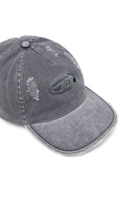 Casquette en denim gris avec des accents usés, visière incurvée et logo brodé. Elle présente une finition texturée et des détails à bords effilochés.