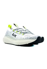 Weiße und graue gemusterte Sneakers mit schwarzem Außensohle, grünen Akzenten, flachem Schnürsystem und einer gepolsterten Zwischensohle für Komfort.