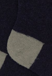 Calzini blu navy con contrasto grigio chiaro sulla punta e sul tallone, realizzati in tessuto morbido e strutturato con motivo a maglia visibile.