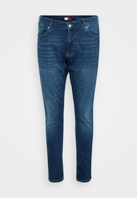 Jeans in denim blu scuro con vestibilità slim. Presentano una chiusura frontale con bottone e zip, cinque tasche e una leggera scoloritura per un effetto texture.