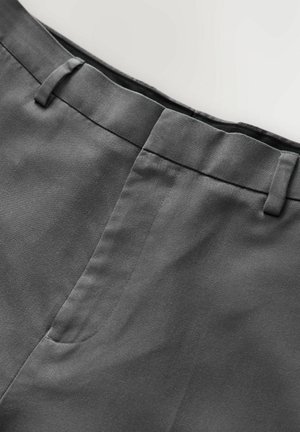 Graue Hose aus glattem, strukturiertem Stoff, mit flacher Vorderseite, Gürtelschlaufen und einem sauberen Bund. Minimalistisches Design, ohne Muster.