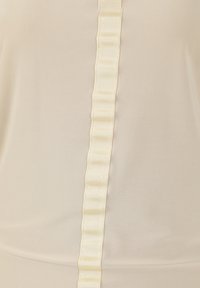 Top beige con dettagli di nastro in satin verticale e pences. Il tessuto appare liscio e leggero, creando una consistenza morbida.