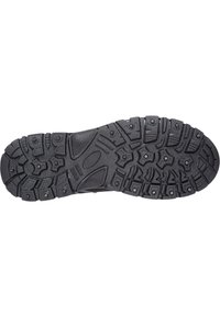 Suola di scarpa sportiva in gomma nera con un motivo di battistrada multidirezionale e chiodi metallici per una maggiore trazione su varie superfici.