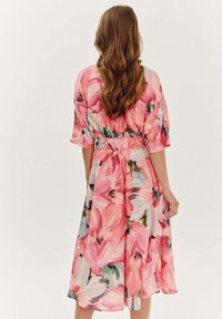 Kvetinové midi šaty s ružovými a zelenými odtieňmi, s elastickým pásom a krátkymi rukávmi, vyrobené z ľahkej tkaniny.