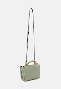 Vihreä nahkainen käsilaukku, jossa on jämäkkä muotoilu, kultaiset yksityiskohdat ja irrotettava olkahihna. Varustettu yläkahvalla ja sivuakseilla.