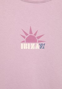 Lyserød kortærmet t-shirt med et grafisk motiv af en sol med spidse stråler, der lægger sig over teksten "IBIZA '91" i kontrasterende farver.