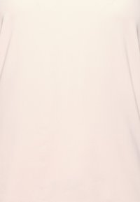 T-shirt à manches courtes, rose clair, fabriqué dans un tissu doux et lisse avec un design simple, sans ornement ni motifs visibles.