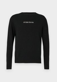 Fekete pulóver hosszú ujjakkal, bordás aljjal és mandzsettával, a "GUESS JEANS" fehér hímzéssel az elején. Puha kötött textúra.