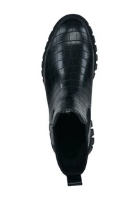 Botín negro hasta el tobillo con una superficie texturizada con patrón de cocodrilo. Presenta una suela de goma y una lengüeta en la parte posterior para facilitar su uso.