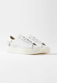 Sneakers bianchi in pelle con suola in gomma rialzata, caratterizzati da un design minimalista, chiusura con lacci e un accento con logo quadrato di lato.