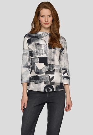 Langärmliges Hemd mit einem schwarz-weißen abstrakten geometrischen Muster, gefertigt aus einem weichen Stoff mit entspanntem Schnitt und rundem Ausschnitt.