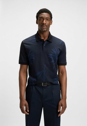 Navy polo shirt with a floral pattern in a darker shade, featuring a black collar, short sleeves, and a button placket. Tailored fit.