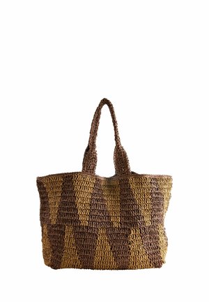 Woven straw tote bag with tall handles, featuring a brown and tan zigzag pattern, standing upright against a white background.