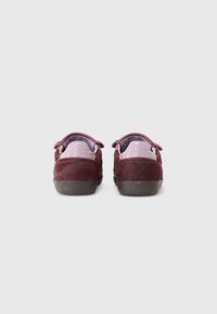 Burgundy sneakers with a textured, faux fur finish. Features a smooth pink heel counter and rubber sole. Designed with two side loops for ease.