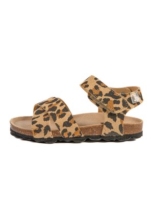 Sandales à imprimé léopard avec des sangles en suede beige, boucle ajustable et semelle en liège. Elles possèdent une semelle en caoutchouc noir texturé et des sangles croisées.