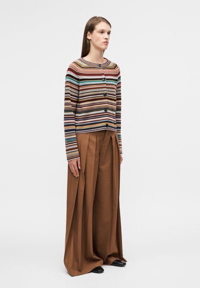 Ριγέ ζακέτα με κουμπιά σε καφέ, μπλε και κόκκινες αποχρώσεις· συνδυάζεται με φαρδιά καφέ παντελόνια με πιέτες· ομαλή υφή σε όλο το ύφασμα.