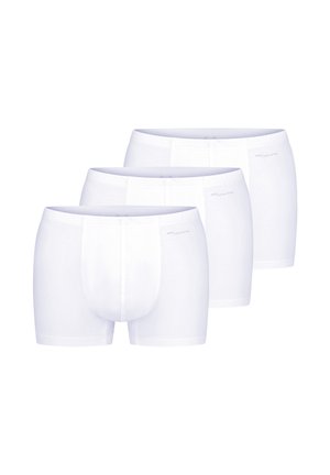 Trzy białe męskie bokserki bawełniane ułożone w przesuniętym rzędzie na białym tle.