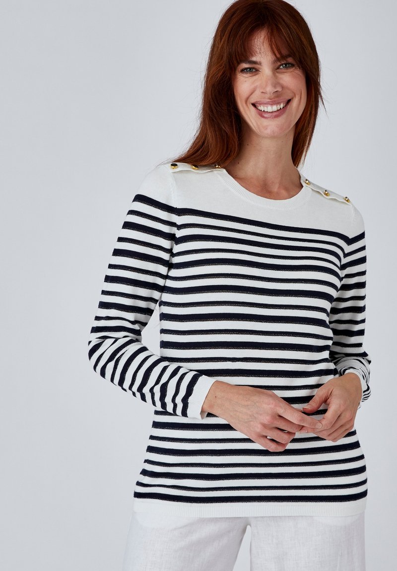 Pull rayé bleu marine et blanc, mettant en avant des accents de boutons dorés sur les épaules, des poignets côtelés et un col rond. Fabriqué en tissu léger.