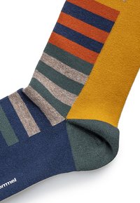 Multifarvet sok med sektioner i blå, orange, grøn, gul og grå, med lodrette og vandrette striber, samt en sømløs tå-design.