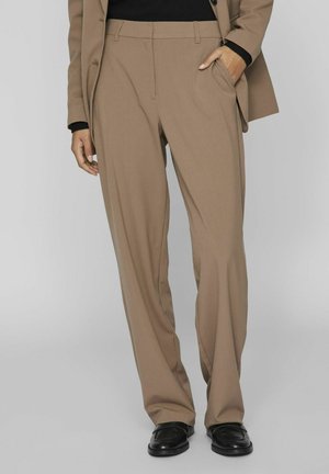 Beige skræddersyede bukser med lige pasform, frontfolder, sidelommer og en glat tekstur, parret med sorte loafers.