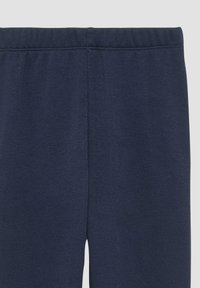 Donkerblauwe leggings van een zachte, textuurstof. Voorzien van een elastische tailleband en stiksel details langs de naden.