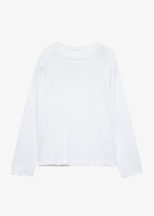 Chemise blanche à manches longues en tissu doux, dotée d'un col rond et de manches raglan avec une coupe ample et peu de détails.