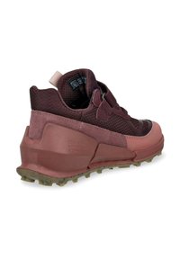 Scarpe sportive color bordeaux con tomaia testurizzata, dettagli in plastica liscia e suola robusta con borchie per una buona aderenza. Chiusura a scatto e tacchi imbottiti.
